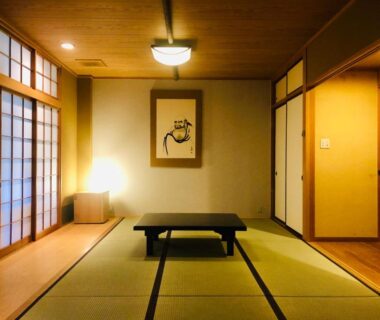 Traditional tatami room with low table, shoji screens, sliding fusuma doors and warm ambient lighting