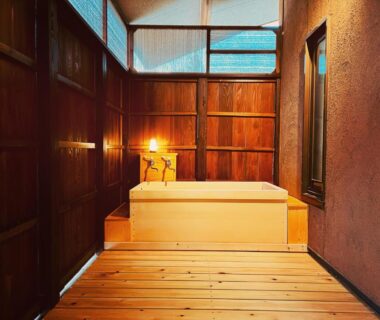 Cozy indoor wooden soaking tub with warm lighting and wood paneling at Ryutakuzenji, Gunma