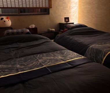 Low twin beds, shoji screen and warm lamp in tatami room at SAKURA inn 白米, Yamanashi