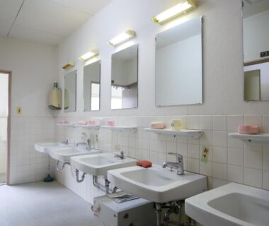 Communal washroom with multiple sinks and mirrors at SDGs BASE AQUA PLUS in Ishikawa