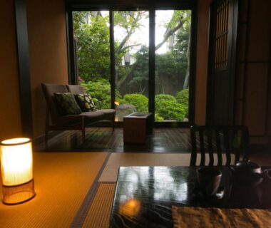 Traditional tatami room with low table, shoji screens and garden view at SEKIYA RESORT Bettei Haruki in Ōita