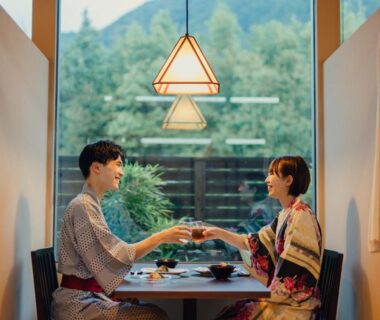 Couple in yukata sharing a meal by window at SEKIYA RESORT Terrace Midoubaru in Ōita Kyūshū