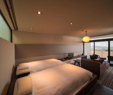 Modern twin room with balcony and coastal view, low table and seating at SEKIYA RESORT Terrace Midoubaru Ōita