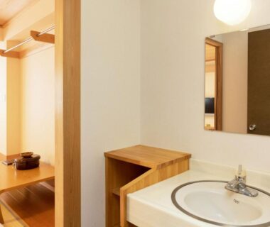 Compact washbasin and mirror with wooden vanity opening to a tatami room and low table