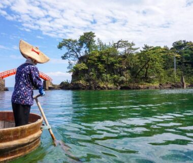 Local boatman in tarai-bune near pine islet at Sado Ryosou Minato, Niigata, Chubu, Japan