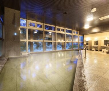 Large tiled indoor onsen bath with floor-to-ceiling windows at Saga Fuga in Saga, Kyūshū