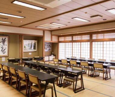 Traditional tatami banquet room with shoji screens, rows of tables and chairs at Sagirisou in Nagano, Chūbu