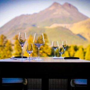 Outdoor table set with wine glasses at Saigakukan, Ōita, Kyushu mountain in background
