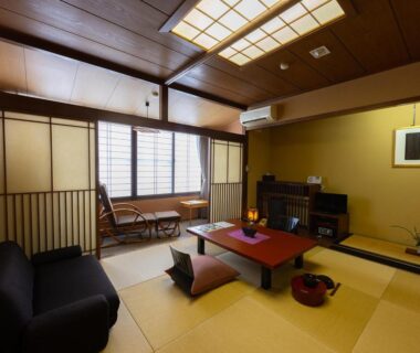 Traditional tatami room with low table, zabuton cushions, shoji screens at Saikatei Jidaiya in Yamagata
