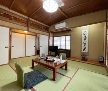 Traditional tatami room with low table, floor chairs, shoji screens and tokonoma at Sakaenoyu Ryokan, Nagano