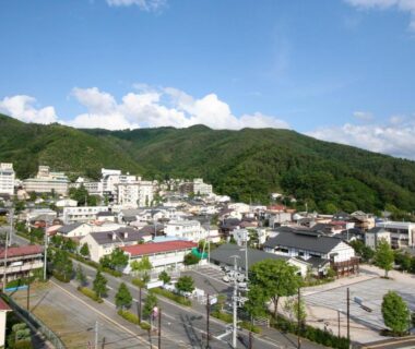 Town and green mountains near Sakaenoyu Ryokan in Nagano, Chūbu, Japan