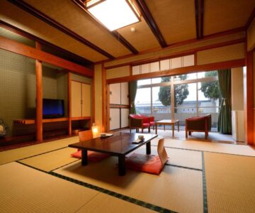 Traditional tatami room with low table, cushions, shoji screens and balcony seating at Sakaeya Hotel, Yamagata, Tōhoku