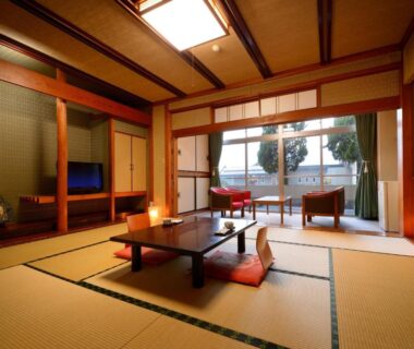 Traditional tatami room with low table, cushions, shoji screens and balcony seating at Sakaeya Hotel, Yamagata, Tōhoku