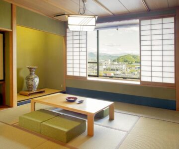 Traditional tatami room with low table, shoji screens and town view at Sakaeya Hotel in Yamagata, Tōhoku
