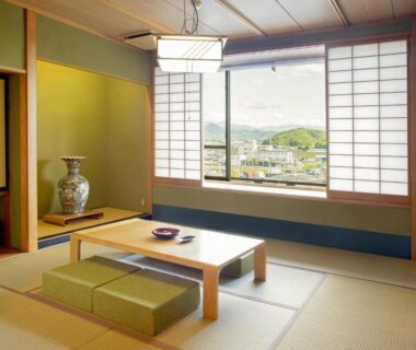 Traditional tatami room with low table, shoji screens and town view at Sakaeya Hotel in Yamagata, Tōhoku