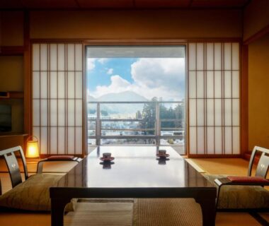 Low table and zaisu on tatami facing shoji doors and balcony view at Sakan, Miyagi, Tōhoku, Japan