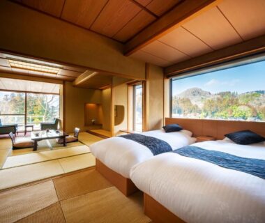 Tatami seating area, twin beds, shoji screens and wide window overlooking tree-covered hills