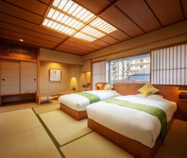 Tatami room with twin beds and shoji screens at Sakan ryokan in Miyagi, Tohoku