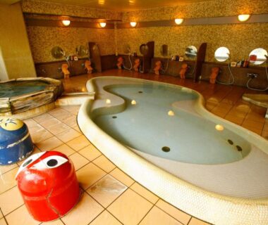 Indoor tiled onsen with wooden tubs and washing stations at Sakaya Ryokan Yoshina Onsen, Shizuoka