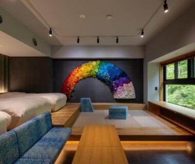 Tatami room with low table, beds and colorful wall art, garden view at Sake Hotel Tamakiya, Niigata Chūbu