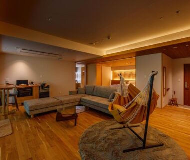 Warm wooden lounge with sofa, hammock and low table at Sakunami Onsen Yuzukushi Salon Ichinobo, Miyagi Tohoku