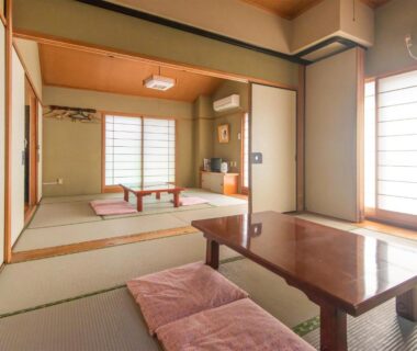 Traditional tatami room with low table, floor cushions, shoji screens and soft natural light