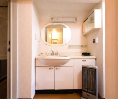 Sink, mirror and cabinet in compact bathroom at Sakura Ryokan Asakusa Tokyo