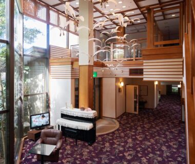 Spacious lobby with wooden beams, mezzanine and large windows at Sakura no Yakata Hotel in Chūbu, Yamanashi, Japan