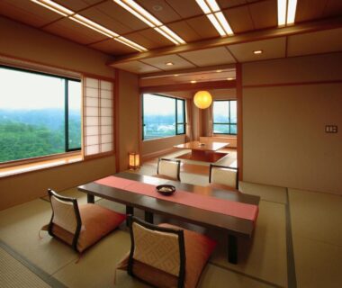 Traditional tatami room with low table, floor chairs, shoji screens and large windows overlooking green Miyagi landscape