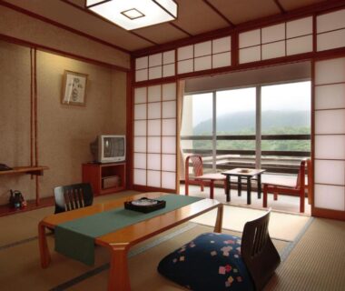 Traditional tatami room with low table, zabuton cushions, shoji screens and sliding glass doors
