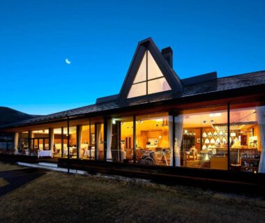 Glass-front ryokan building lit at twilight with warm interior lighting, Sanso Amanosato, Wakayama