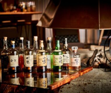 Bottled spirits on wooden table beside fireplace in Sanso Amanosato ryokan, Wakayama