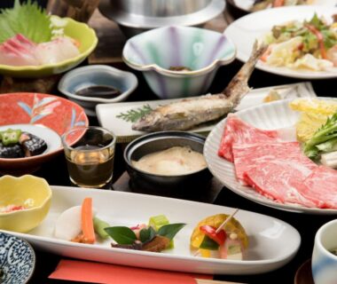 Ceramic dishes with sashimi, simmered vegetables, soup and sliced beef arranged for a ryokan multi-course meal