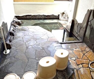 Stone floor indoor onsen with wash stools and small bath at Sanso Tanaka, Oita, Kyūshū