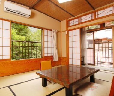 Traditional tatami room with low table, shoji screens and balcony overlooking garden at Sansou Nagisa Kanagawa