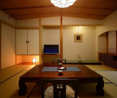 Traditional tatami room with low wooden table, shoji screens, recessed alcove and soft lantern lighting in Fukushima ryokan