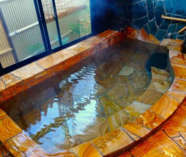 Stone-lined indoor onsen bath with wooden window, Sansuisou ryokan, Kanagawa prefecture