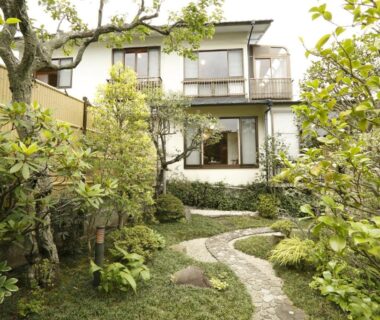 Stone path through lush garden leading to Sansuisou building with balcony in Kanagawa, Kantō