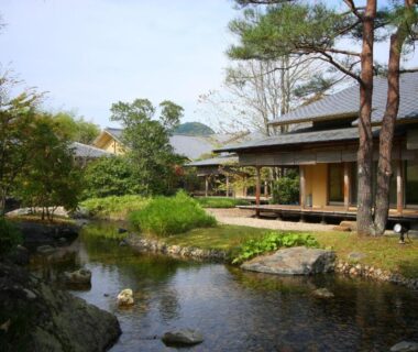 Reflecting garden pond with wooden veranda beside traditional ryokan building at Saryo Souen in Miyagi Tōhoku