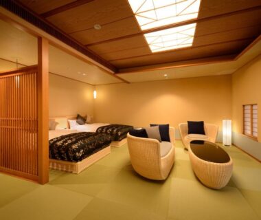 Tatami-floored guest room with two low beds and woven lounge chairs at Saryo Souen in Miyagi, Tōhoku
