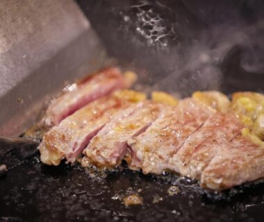 Searing sliced steak on hot iron griddle at Sasai Hotel in Hokkaidō