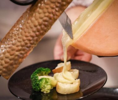 Sauce poured over plated seafood with broccoli garnish