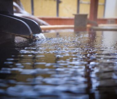 Close-up of water flowing into a wooden onsen bath inside Sasai Hotel, Hokkaido