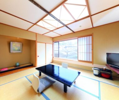 Tatami room with low table, shoji window, tokonoma and TV at Sasakura Onsen Ryuunso in Niigata, Chūbu