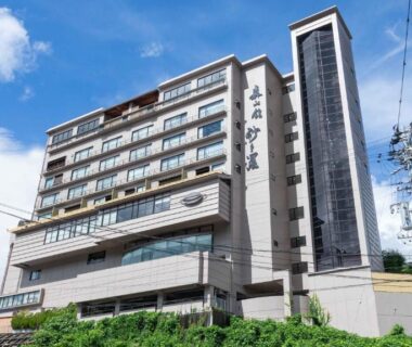 Multi-story ryokan exterior with signage at Sasara above hillside greenery in Chūbu Gifu Japan