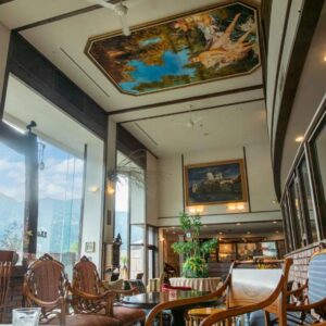 Interior lounge with painted ceiling, wooden chairs and tall windows at Sasara in Gifu, Chūbu, Japan