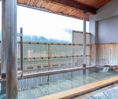 Roofed wooden onsen bath overlooking mountain landscape at Sasara in Gifu