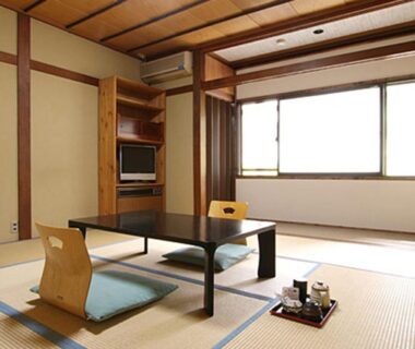 Traditional tatami room with low table and cushions at Schole Hakuba, Nagano