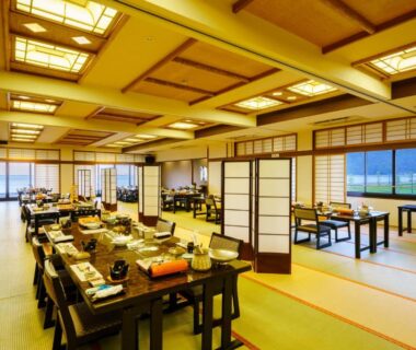 Large tatami dining room with low tables, shoji screens and warm lighting at Seaside Hotel Mimatsu Ooetei in Oita