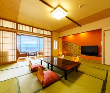 Tatami room with low table, cushions, shoji screens and balcony overlooking the sea